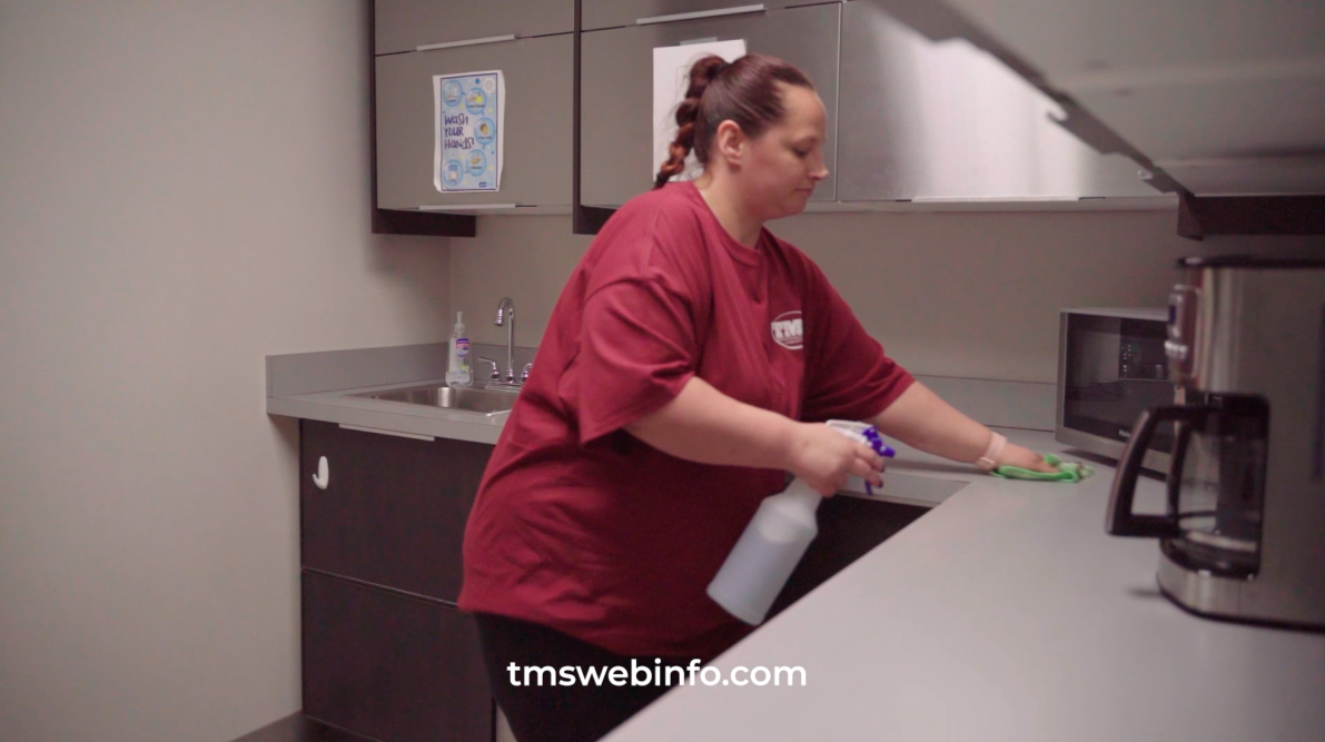 A woman cleaning a kitchen counter